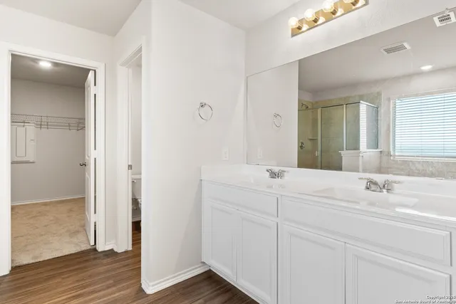 a bathroom with a double vanity sink mirror and next to a white cabinet