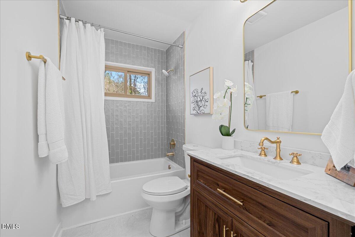 1406 Valley Road Garner, NC 27529 - Photo 18 of 39 a bathroom with a sink a toilet and shower