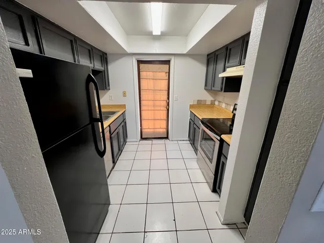 a kitchen with stainless steel appliances granite countertop a refrigerator and a sink
