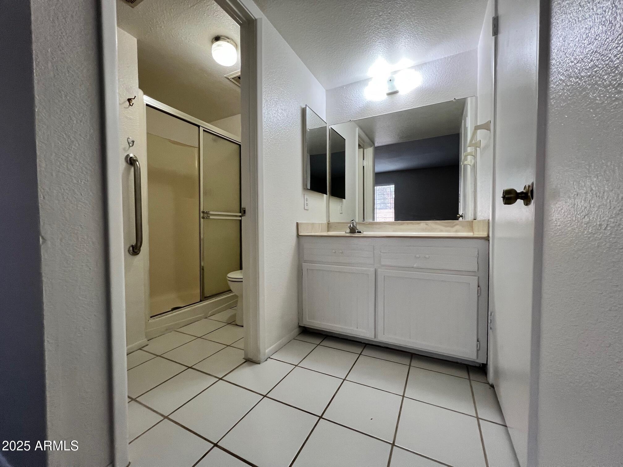 1927 East Hampton Avenue, Unit 136 Mesa, AZ 85204 - Photo 20 of 26 a bathroom with a sink a large mirror and a shower