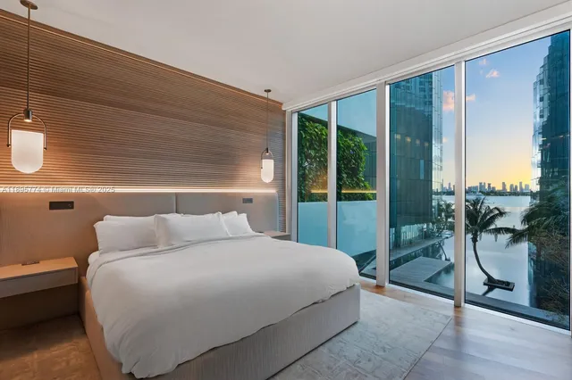 a bedroom with a bed and a potted plant next to a window