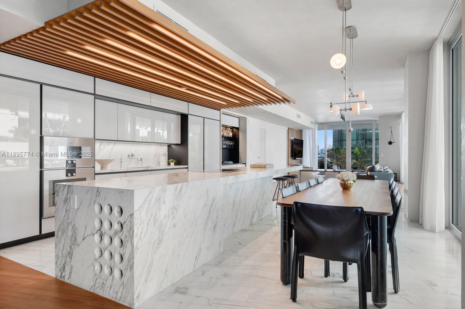 1300 Monad Terrace, Unit 3B Miami Beach, FL 33139 - Photo 6 of 35 a kitchen with stainless steel appliances kitchen island granite countertop a table chairs and white cabinets