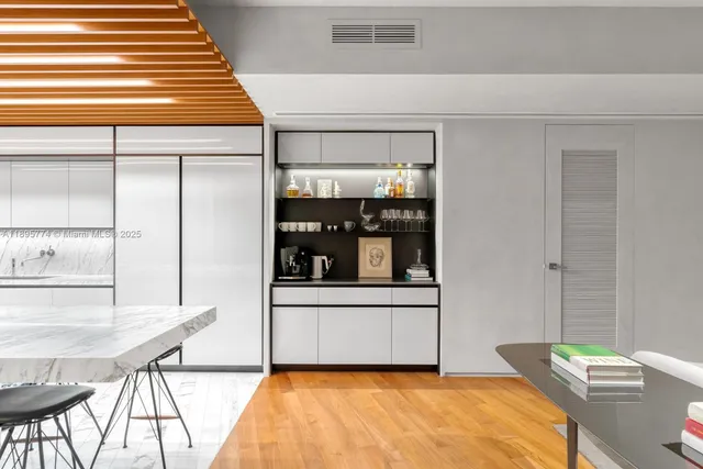 a kitchen with a kitchen island white cabinetry and chairs