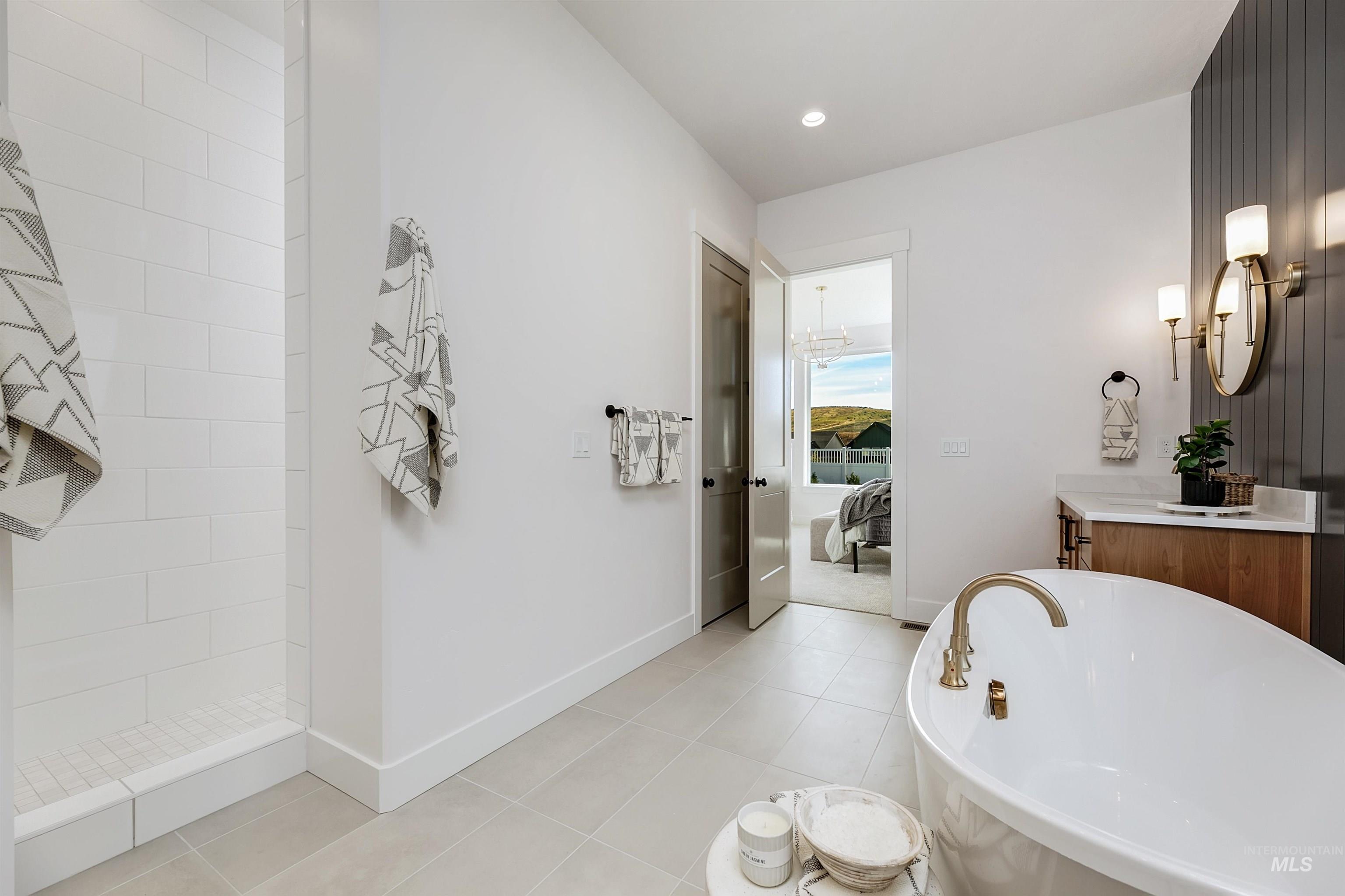 13623 North Ruffed Grouse Way Boise, ID 83714 - Photo 15 of 45 Ensuite bathroom with vanity, a freestanding tub, light tile patterned floors, and recessed lighting