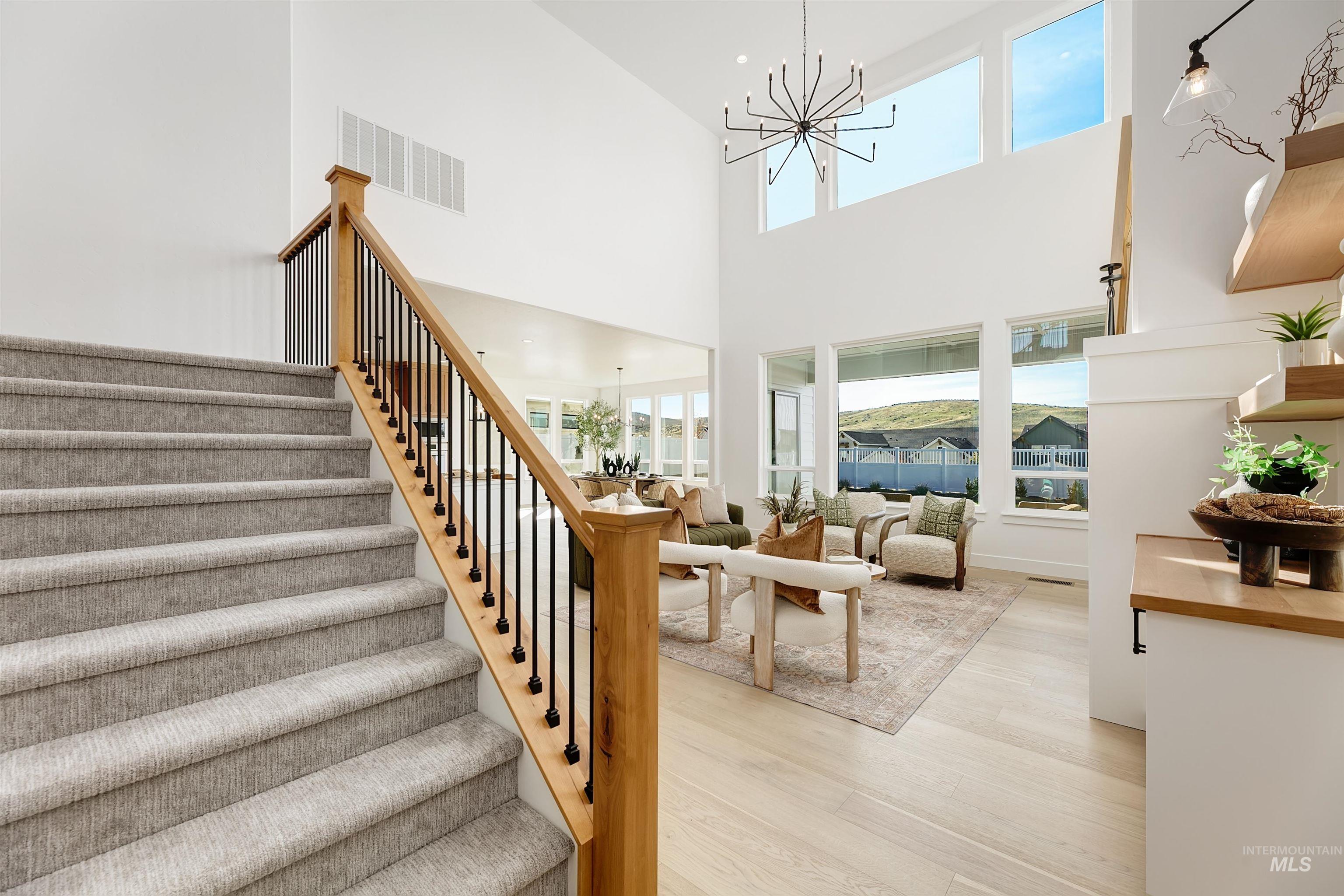 13623 North Ruffed Grouse Way Boise, ID 83714 - Photo 19 of 45 Stairs with a chandelier, wood finished floors, and a towering ceiling
