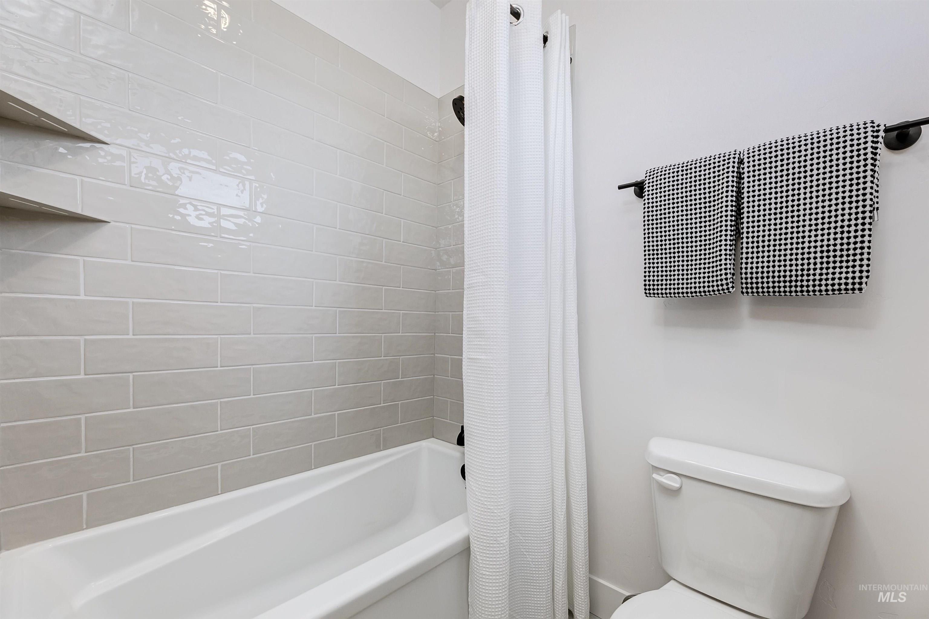 13623 North Ruffed Grouse Way Boise, ID 83714 - Photo 28 of 45 Bathroom featuring shower / bath combo with shower curtain and toilet