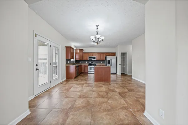 a large kitchen with a refrigerator and a stove top oven