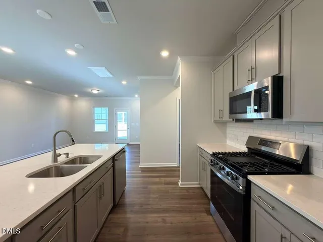 a kitchen with stainless steel appliances granite countertop a sink and a stove