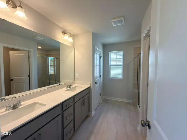a bathroom with a sink double vanity granite tub and shower