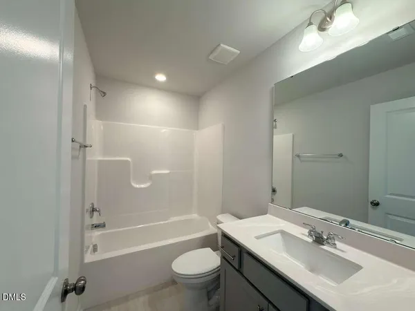a bathroom with a sink a toilet a mirror and shower