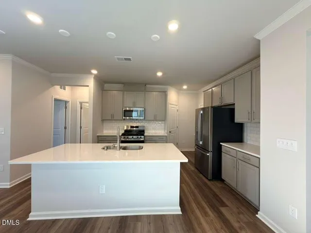 a kitchen with stainless steel appliances a refrigerator sink and microwave