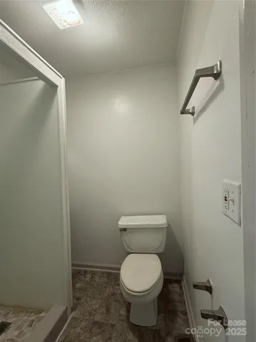 a white toilet sitting next to a shower