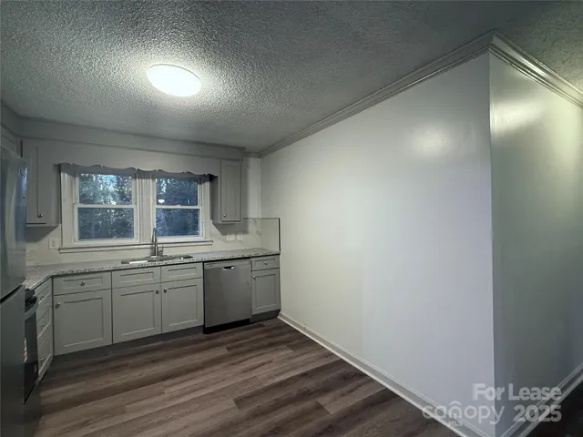 a view of a kitchen with sink dishwasher and wooden floor