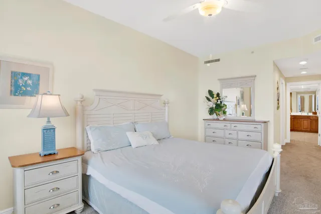 a bedroom with a bed and a lamp on dresser