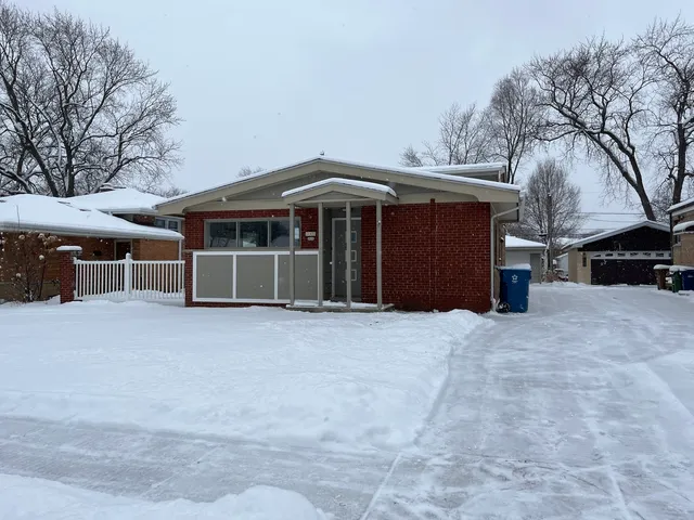 a view of a house with a yard and a large tree