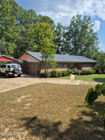 a view of house with yard and outdoor seating