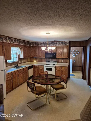 a kitchen with granite countertop a sink a counter top space stainless steel appliances and cabinets