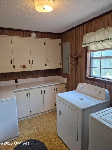 a utility room with cabinets washer and dryer