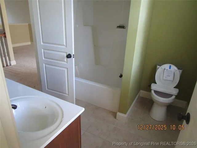 a view of an empty room with closet and a window