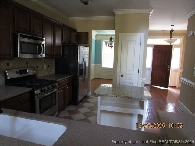 a kitchen with stainless steel appliances granite countertop a stove refrigerator and microwave