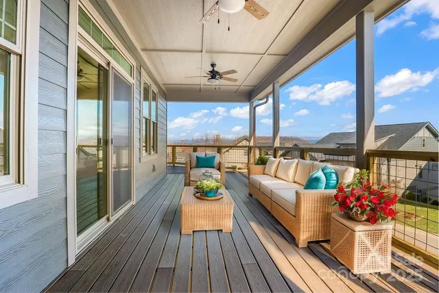 a view of a balcony dining room with furniture a chandelier and wooden floor