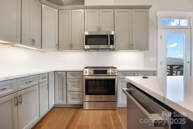 a kitchen with stainless steel appliances a stove a microwave and cabinets