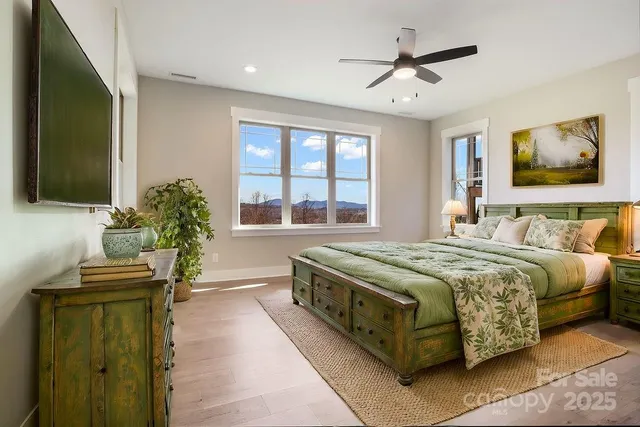 a spacious bedroom with a large bed and a chandelier