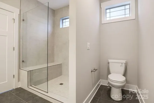 a bathroom with a toilet and a shower