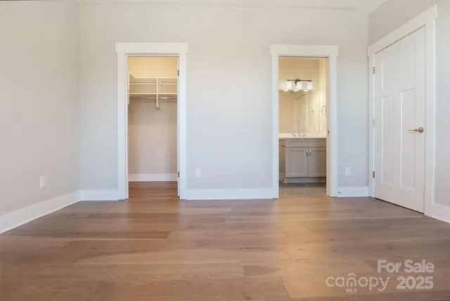 a view of an empty room with closet and a window