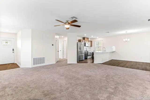 a view of kitchen with stainless steel appliances granite countertop stove top oven and cabinets
