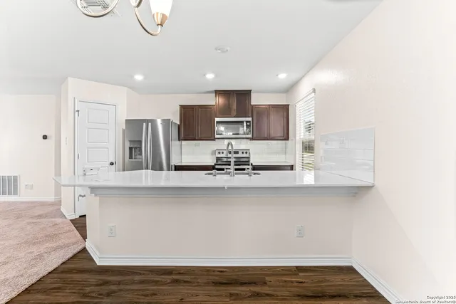 a kitchen with stainless steel appliances granite countertop a refrigerator stove and sink