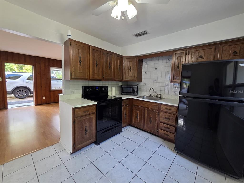 7216 James Street Port Richey, FL 34668 - Photo 11 of 28 a kitchen with a refrigerator sink and cabinets