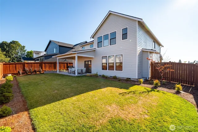 a view of a house with backyard and sitting area