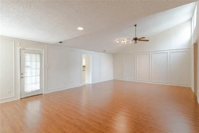 a view of an empty room with window and wooden floor