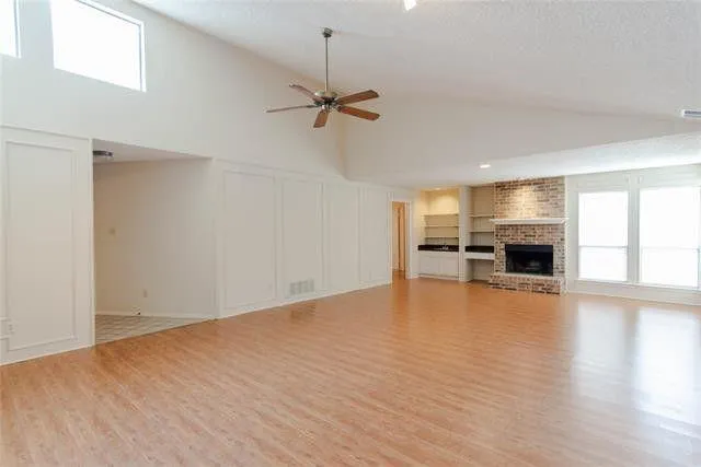 a view of a kitchen and an empty room with a window