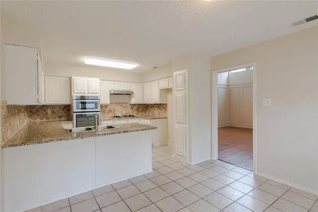 a kitchen with stainless steel appliances granite countertop a sink and cabinets