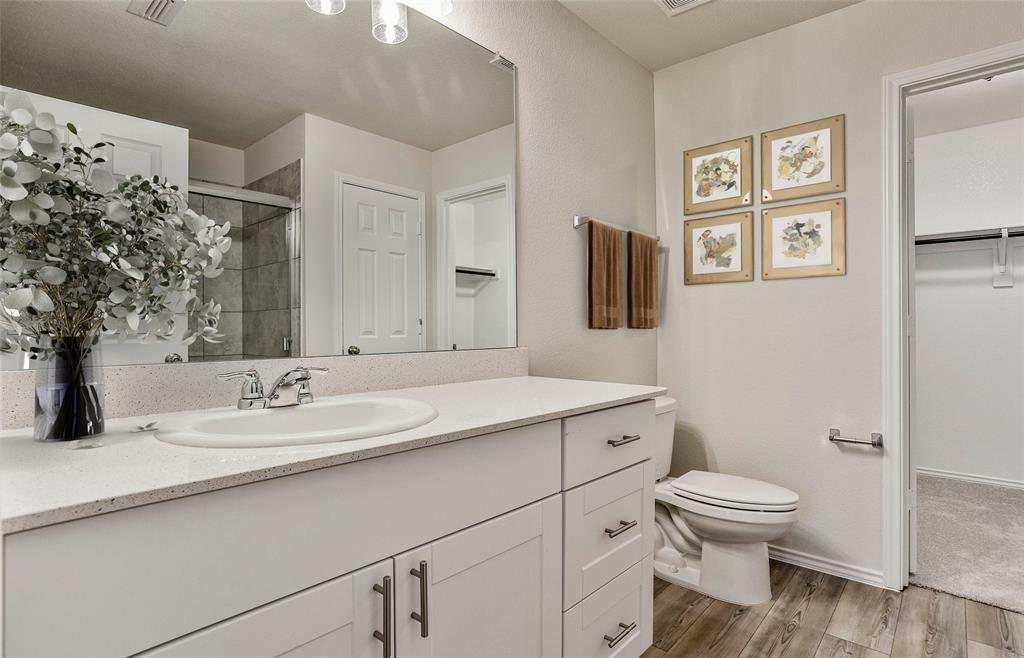 14057 Ladbroke Street Pilot Point, TX 76258 - Photo 8 of 11 a bathroom with a toilet sink and mirror