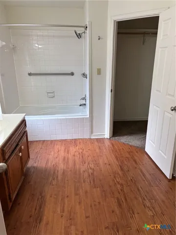 a view of walk in closet with wooden floor and staircase