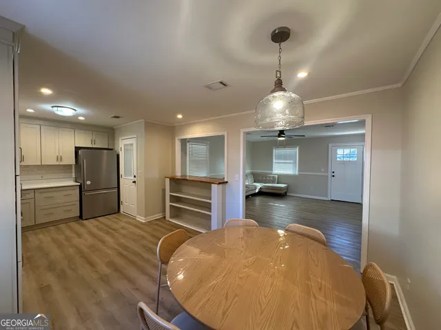 a kitchen with refrigerator a sink and chairs