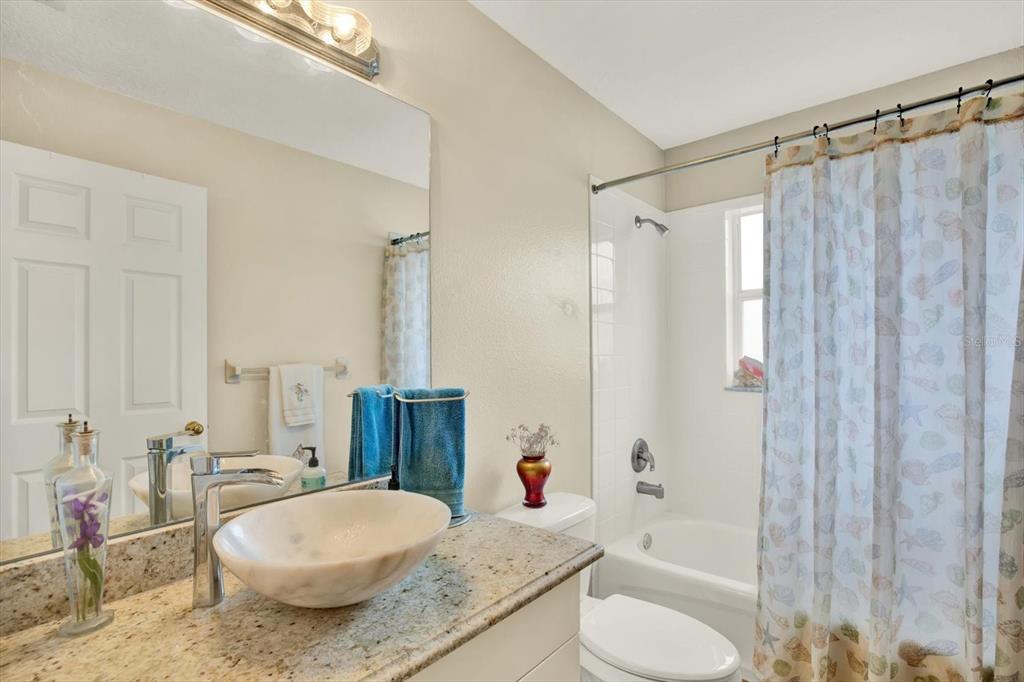 2021 Meadow Rue Court Trinity, FL 34655 - Photo 19 of 41 a bathroom with a granite countertop sink toilet and shower