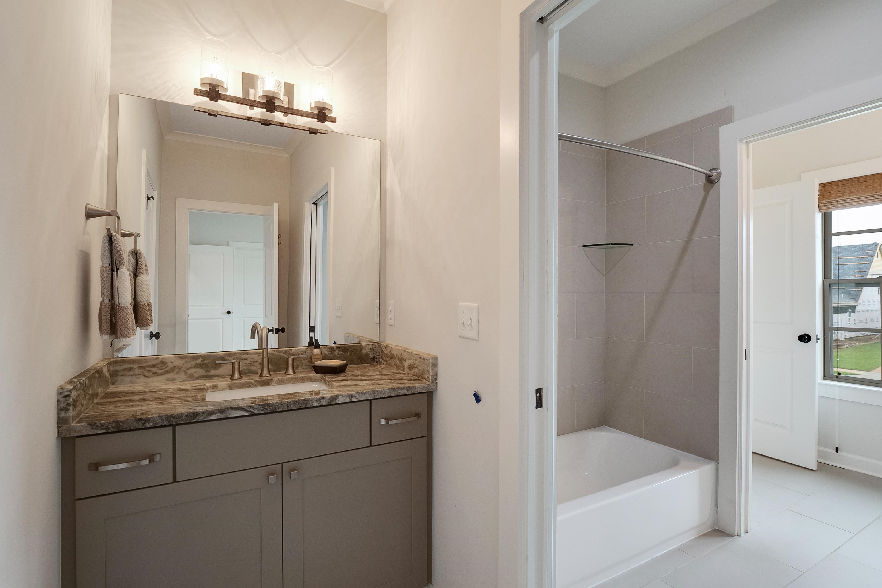 1365 Belfair Drive Collierville, TN 38017 - Photo 34 of 39 a bathroom with a granite countertop sink mirror and a bathtub