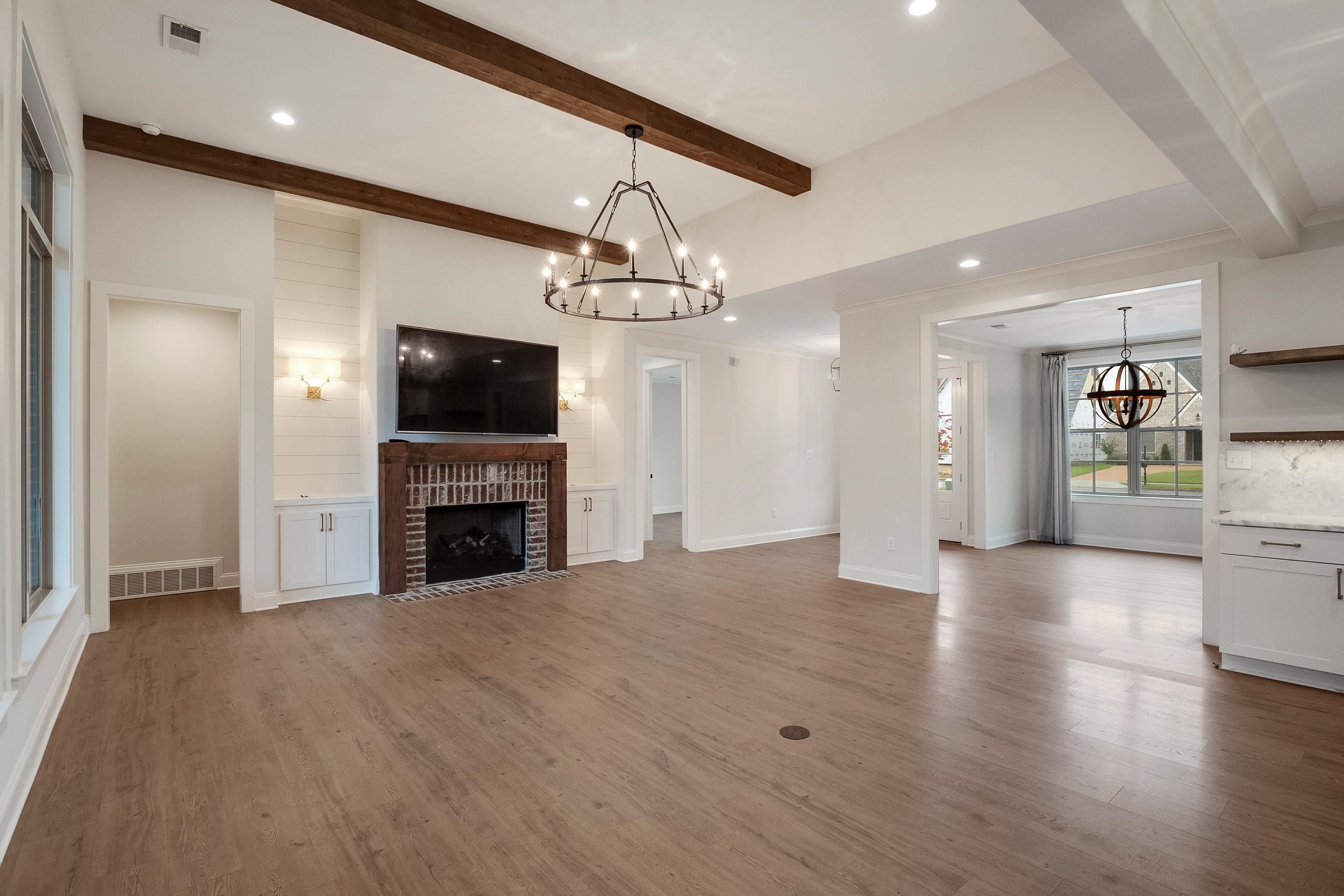 1365 Belfair Drive Collierville, TN 38017 - Photo 6 of 39 a view of a livingroom with a fireplace a chandelier and wooden floor