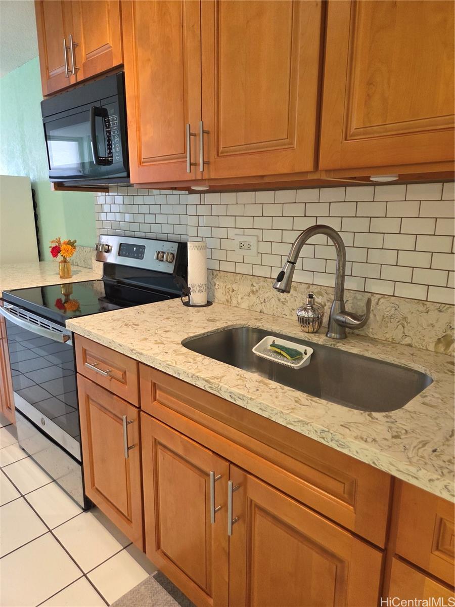 a kitchen with stainless steel appliances granite countertop a sink a stove and cabinets