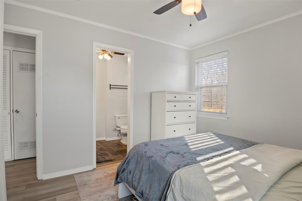 3518 Windsor Street Irving, TX 75062 - Photo 11 of 21 a bedroom with a bed and a chandelier