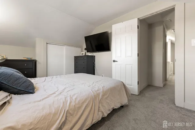 a bedroom with a bed and a flat tv screen on wall