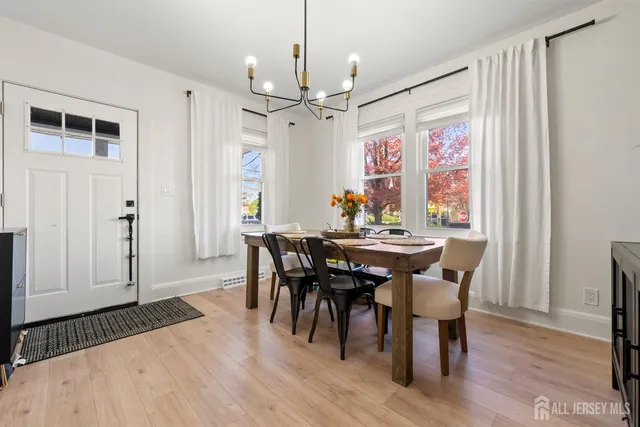 a view of a a dining room with furniture window and wooden floor