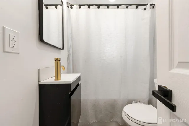 a bathroom with a toilet a sink and curtain