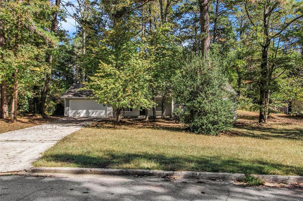 1748 Charmeth Road Lithonia, GA 30058 - Photo 22 of 32 a view of a yard with plants and trees