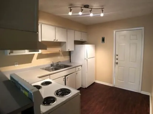 a kitchen with a stove a refrigerator and a sink
