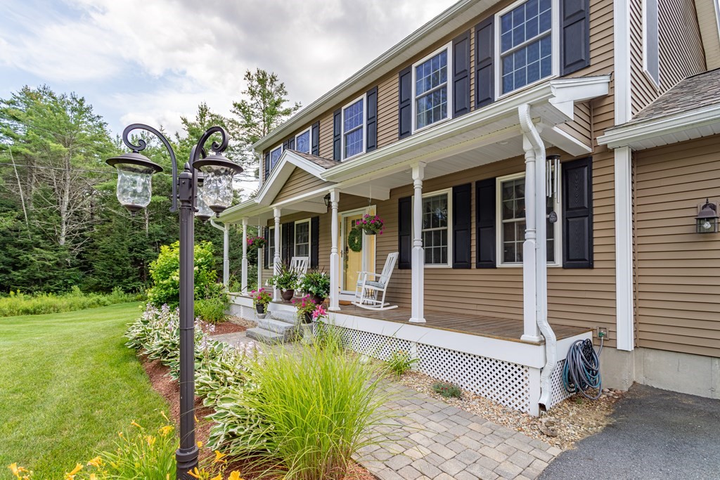 145 Tuckerman Road Ashburnham, MA 01430 - Photo 37 of 42 a view of a brick house with a large windows and flower plants
